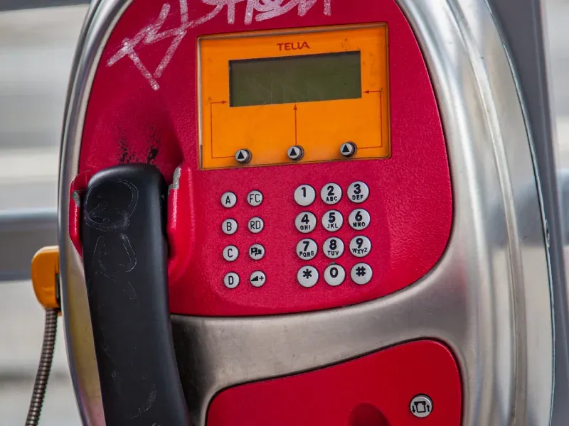 Röd telefonautomat med tangentbord och display