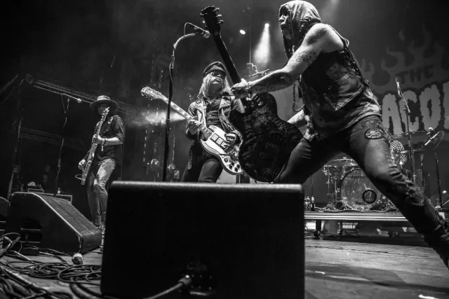 Band med gitarrister på scen i svartvitt
