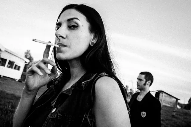Kvinna med cigarett i munnen i svartvitt