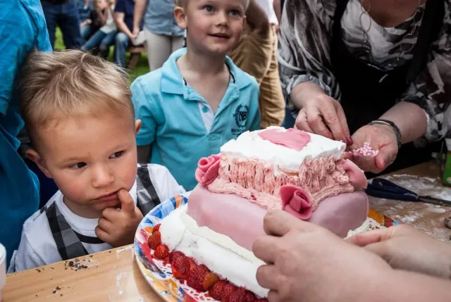 Barn tittar på en rosa tårta på ett bord