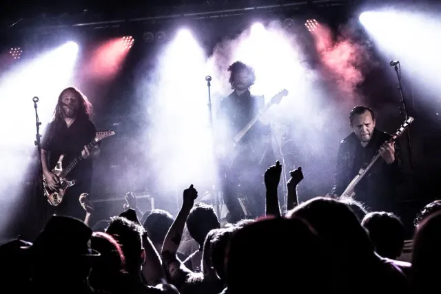 Band spelar på scen med publik i silhuett
