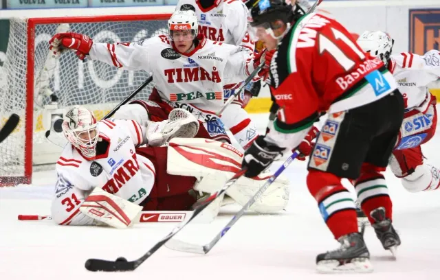 Ishockeyspelare vid mål med målvakt på isen