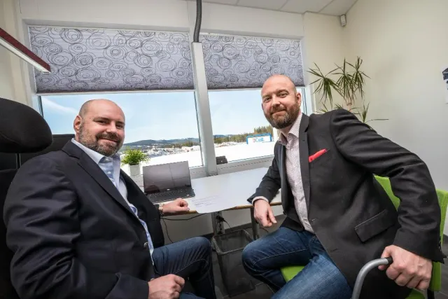 Två män i kostym sitter på ett kontor